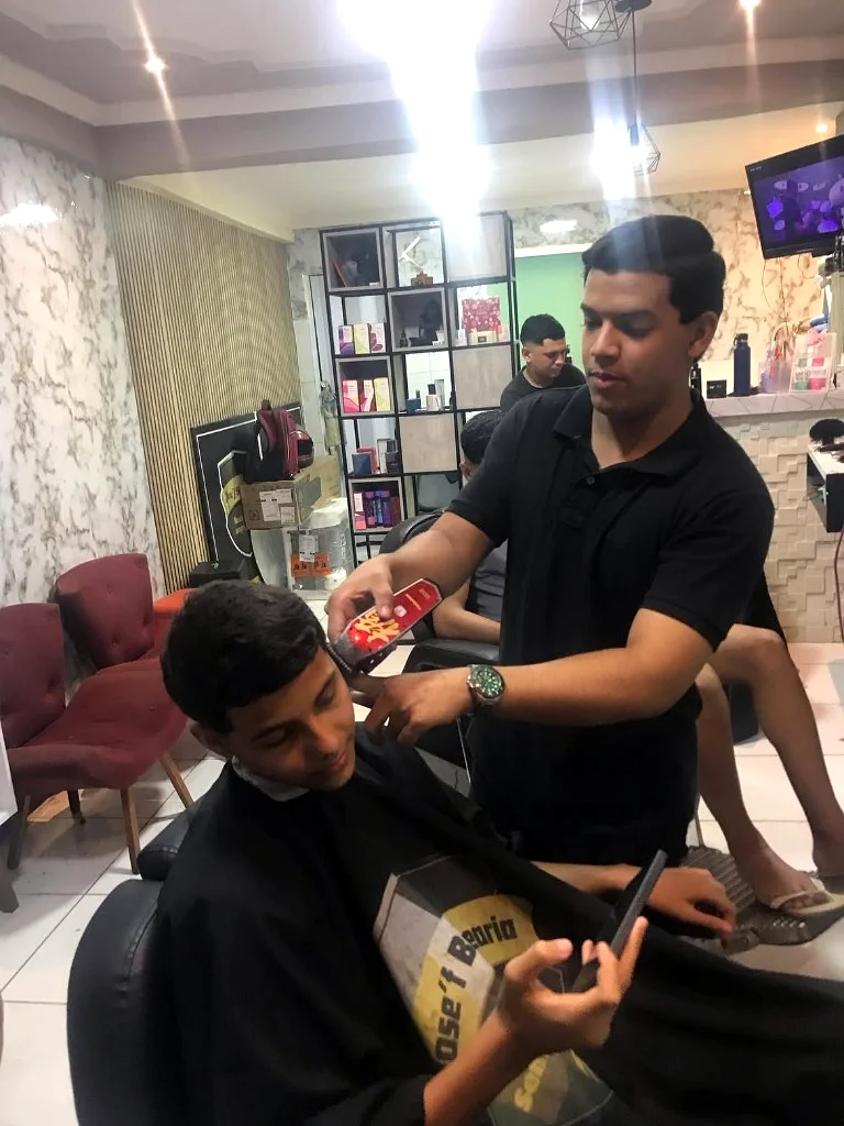 Profissionais da barbearia reunidos no ambiente de atendimento